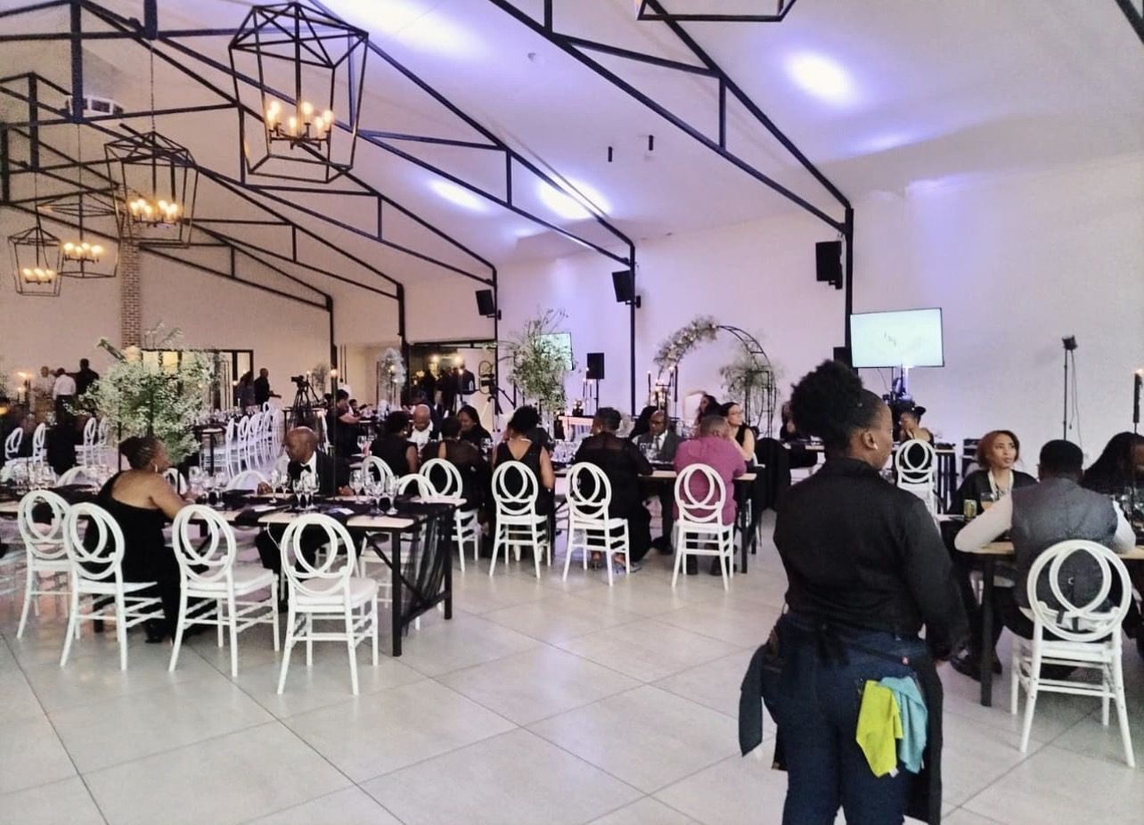 Wedding reception with guests seated and a screen displaying content